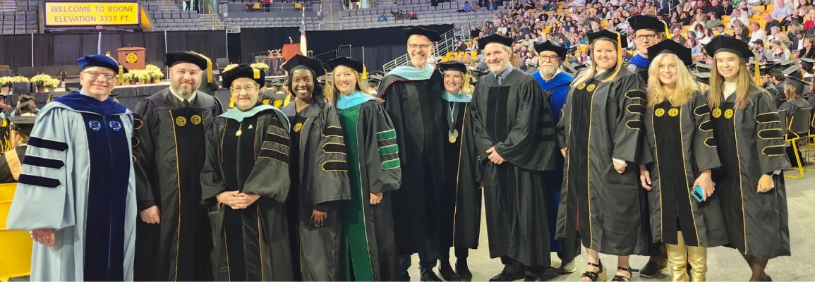 Appalachian State EdD Doctoral students and chairs posing for picture in the Convocation Center at the Fall 2023 commencement ceremony