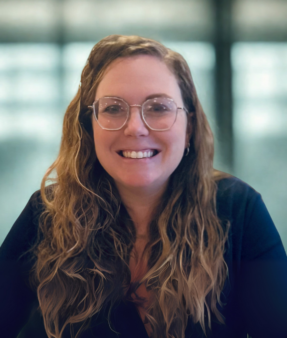 Dr. Hannah Jimenez with long hair wearing a navy shirt and fun, trendy glasses.