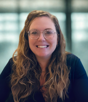 Dr. Hannah Jimenez with long hair wearing a navy shirt and fun, trendy glasses.
